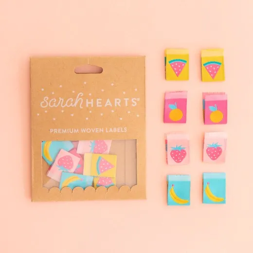Sarah-Hearts-Weblabel „Summer Fruits" in Kraftpapier-Verpackung neben allen acht Labels mit Orange-, Erdbeer-, Wassermelonen- und Bananen-Motiv.