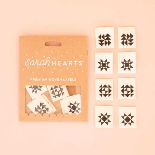 Verpackung der Sarah Hearts Weblabel „Quilt Block" mit acht Labels in schwarz-weißen Quiltblock-Mustern auf naturfarbenem Stoff.