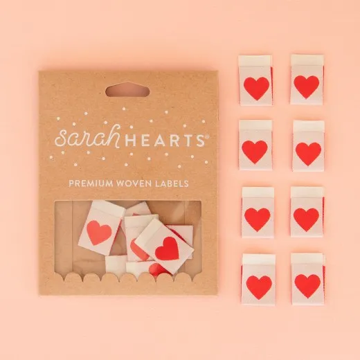 Verpackung Red Heart Kraftpapier-Verpackung der Sarah Hearts Weblabels "Red Heart" mit rotem Herz-Motiv auf cremefarbenem Hintergrund.