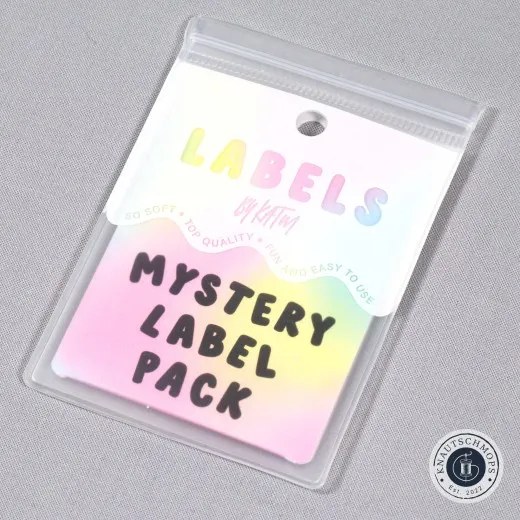 Verpackung schräg fotografiert Holografisch schimmernde Verpackungskarte „Mystery Label Pack" von KATM, schräg fotografiert.