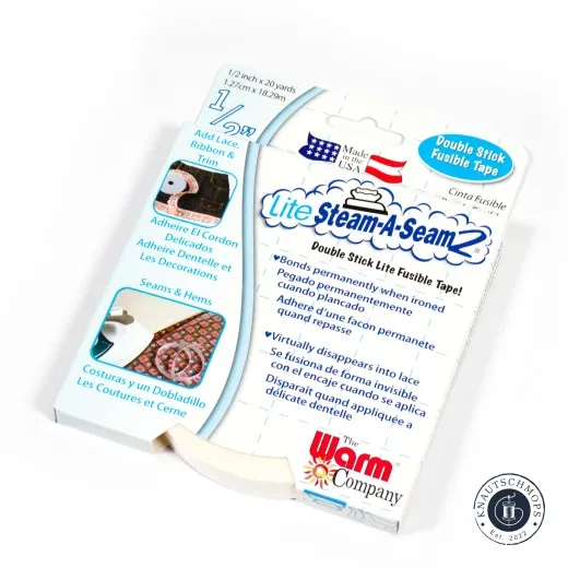 Verpackung schräg fotografiert Verpackung „Lite Steam-A-Seam 2" von The Warm Company, doppelseitig klebendes Bügelvlies-Band 1,27cm, schräg fotografiert mit sichtbarer Tape-Rolle am unteren Rand.