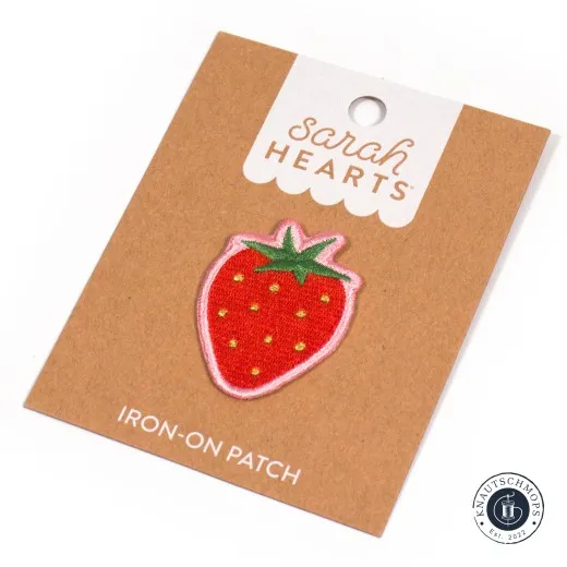 Verpackung schräge Ansicht Sarah Hearts Iron-On Patch „Strawberry" in Erdbeerform mit Gold-Akzenten, schräg auf der Verpackungskarte fotografiert.