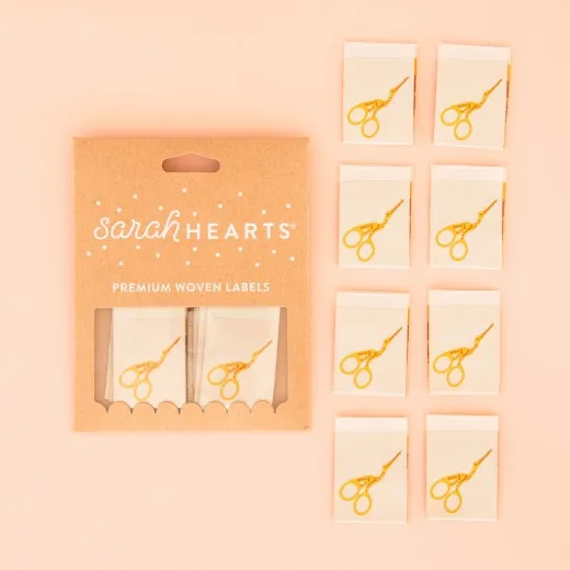 Verpackung Storchenschere Gold Label Verpackung der Sarah Hearts Weblabel „Stork Scissors" mit acht naturfarbenen Labels und goldenem Storchenscheren-Aufdruck.
