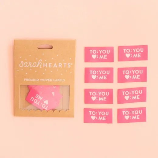 Kraftpapier-Verpackung der Sarah Hearts Weblabels "To: You, Herz: Me" in Pink mit cremefarbenem Text.
