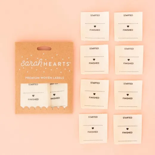 Verpackung und Etiketten-Übersicht Verpackung der Sarah Hearts Weblabel „Started/Finished" mit acht cremefarbenen Bio-Baumwoll-Etiketten zum Ausfüllen.