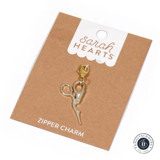 Sarah Hearts Zipper Charm „Storchen-Stickschere“ in Gold mit Karabiner auf der Original-Verpackungskarte.