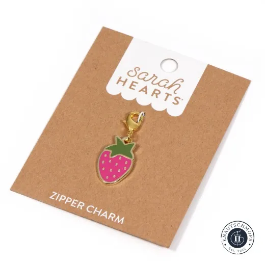 Zipper Charm auf Verpackungskarte Sarah Hearts Zipper Charm „Strawberry“ in Form einer pinken Erdbeere mit grünem Blattkranz und Karabiner auf der Verpackungskarte.