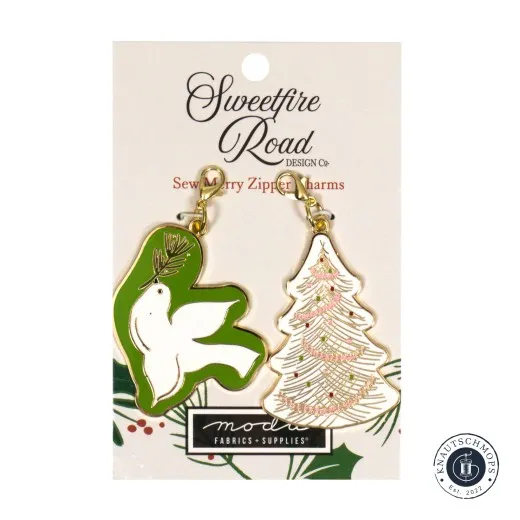 Zwei goldene Emaille-Anhänger von Sweetfire Road: ein bestickter weißer Weihnachtsbaum und eine grün-weiße Friedenstaube mit Tannenzweig, auf Verpackungskarte 'Sew Merry Zipper Charms'.