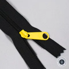 Nahaufnahme eines gelben XL-Zippers auf dem schwarzen Reißverschlussband