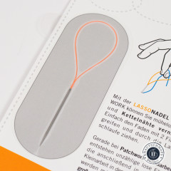 Nahaufnahme der Lasso Nadel mit oranger 60 mm Schlaufe und Metallnadel auf der Verpackungskarte