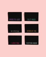 Sechs schwarze Metallic-Labels mit sechs verschiedenen Sprüchen, Frontalansicht