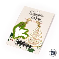 Nahaufnahme des weißen Anhängers in Form eines bestickten Weihnachtsbaums mit bunten Perlen.