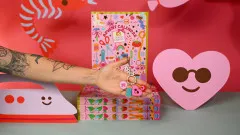 Hand mit KATM Schlüsselanhänger vor gestapelten Adventskalender-Boxen 2026