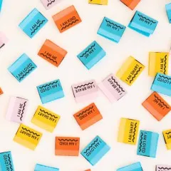 Weitere Nahaufnahme der orangen, gelben, rosa und blauen Affirmations-Weblabels mit „I AM ME"-Gegenstücken.