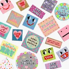 Alle rund 19 Labels des Wearable-Art-Sets locker verstreut auf weißem Hintergrund, darunter „Fancy Dress", „Cutie Pie", „Human Rainbow" und „Very Razzle Dazzle".