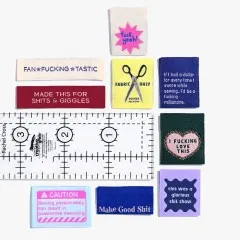 Alle neun Labels des „Sweary Sewist #4"-Sets nebeneinander auf weißem Hintergrund neben einem Lineal.