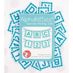Verpackung der It's Sew Emma Alphabitties in Blue, umgeben von verstreuten Buchstaben- und Zahlenplättchen