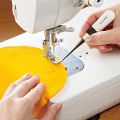 Die gebogene Ahle wird zum Führen des Stoffes direkt an der Nähmaschinennadel eingesetzt.