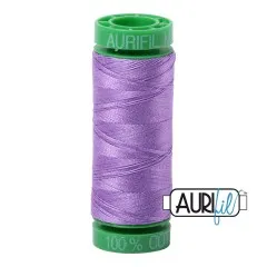 Garnrolle Aurifil 40wt in Violet (Fb. 2520) mit grünen Endkappen vor weißem Hintergrund.