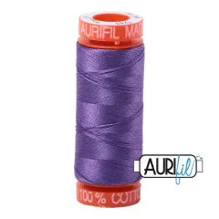 Orangefarbene Aurifil-Garnspule mit 50wt-Baumwollgarn in der Farbe Dusty Lavender (gedecktes Lavendel) vor weißem Hintergrund.