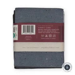 Rückseite der Banderole mit Barcode, Materialangabe und Waschhinweisen auf blaugrauem Stoff.