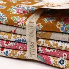 Nahaufnahme des Baumwollbands mit Tilda-Quilt-Schriftzug am Stoffbündel