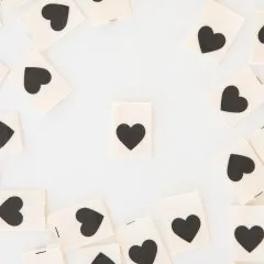 Sarah Hearts Weblabels „Black Heart" locker verteilt auf weißem Untergrund