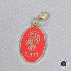 Nahaufnahme des runden Anhängers mit dem Schriftzug 'Bloom'.