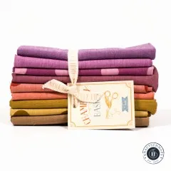 Das Fat-Quarter-Bundle von vorne mit sichtbarem Farbverlauf von Beere über Orange bis Braun.