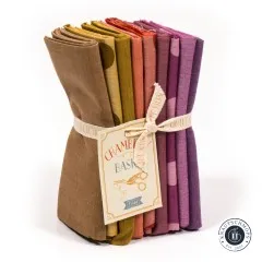 Gestapeltes Tilda Fat-Quarter-Bundle „Seasonal Chambray – Autumn" in Braun-, Senf-, Orange- und Beerentönen mit Chambray-Basics-Anhänger.