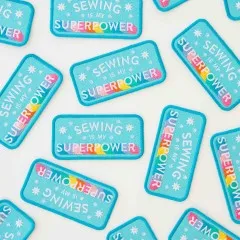 Weitere Nahaufnahme der Patches mit bunter Regenbogenschrift aus anderem Blickwinkel.