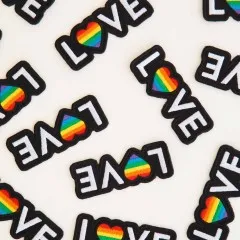 Weitere Nahaufnahme der „Love"-Patches aus anderem Blickwinkel, teils quer liegend.