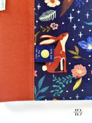 Label „Love You To The Moon and Back" eingenäht in die Nahtzugabe einer Tasche mit Hasen- und Blumenmuster.