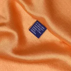 Label „If I had a dollar for every time I swore while sewing..." eingenäht in glänzenden orangefarbenen Satin.