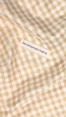 Label „Fan-Fucking-Tastic" eingenäht in beige-weiß karierten Vichy-Stoff.