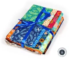 Stoffbündel aus grünen, blauen, orangen und pinken Baumwollstoffen der Kollektion Enchanted mit Satinband