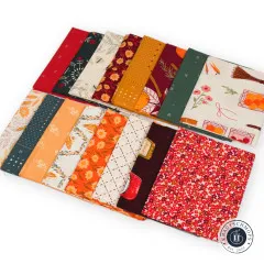 Alle 16 Fat Quarters fächerförmig ausgelegt mit herbstlichen Blumendrucken, Karos und Unistoffen in Rot, Grün und Ocker.