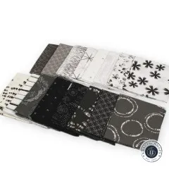 Alle 16 Fat Quarters fächerförmig ausgelegt, Grafikmuster und Unistoffe in Schwarz, Grau und Weiß.