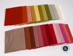 Alle 25 Stoffquadrate des Warm-Colors-Bundles einzeln aufgefächert in zwei Reihen