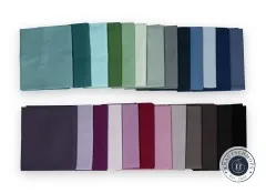 Alle 25 Stoffquadrate des Cool-Colors-Bundles einzeln aufgefächert in zwei Reihen