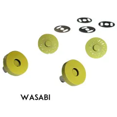 Vier gelbgrüne Druckknopf-Hälften und vier Metall-Unterlegscheiben, mit dem Schriftzug „WASABI" zur Farbbezeichnung.