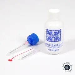 Roxanne-Glue-Baste-It-Flasche freistehend neben den beiden Applikatornadeln.