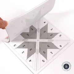 Nahaufnahme der nummerierten Foundation-Paper-Piecing-Vorlage für den Woven-Star-Block beim Abziehen des oberen Blatts.