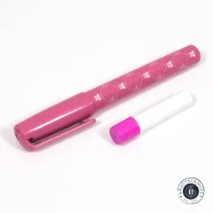 Geöffneter pinker Kleberstift mit gemusterter Hülse neben der abgenommenen Kappe