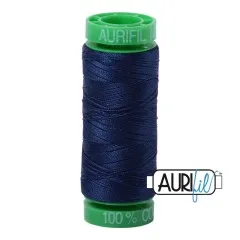 Aurifil-Garnrolle mit grünen Endkappen und dunkelblauem, marineblauem Baumwollgarn.