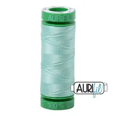 Aurifil-Garnrolle mit grünen Endkappen und zartem, hellem Mintgrün-Baumwollgarn.