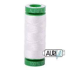 Aurifil-Garnrolle mit grünen Endkappen und reinweißem Baumwollgarn.