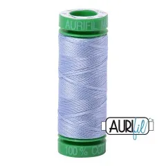 Aurifil-Garnrolle mit grünen Endkappen, bespult mit zartem, hellblauem Baumwollgarn in Delfter-Blau-Nuance.