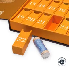 Nahaufnahme der Adventskalender-Fächer mit einer entnommenen Aurifil-Garnspule vor dem geöffneten Türchen 22.