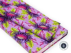 Gefalteter Stoffballen des Anemonenmusters in Violett mit sichtbarem Herstelleretikett am Rand.